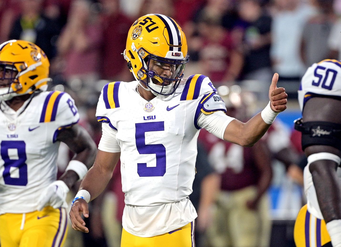 Jayden Daniels (5) gives a thumbs up during the first half against the Florida State Seminoles at Camping World Stadium.