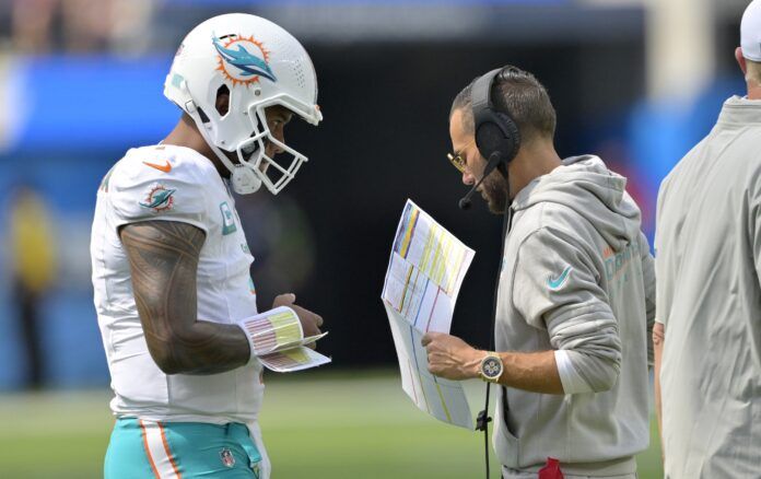 Mike McDaniel talks with quarterback Tua Tagovailoa (1) during a time out against the Los Angeles Chargers at SoFi Stadium.