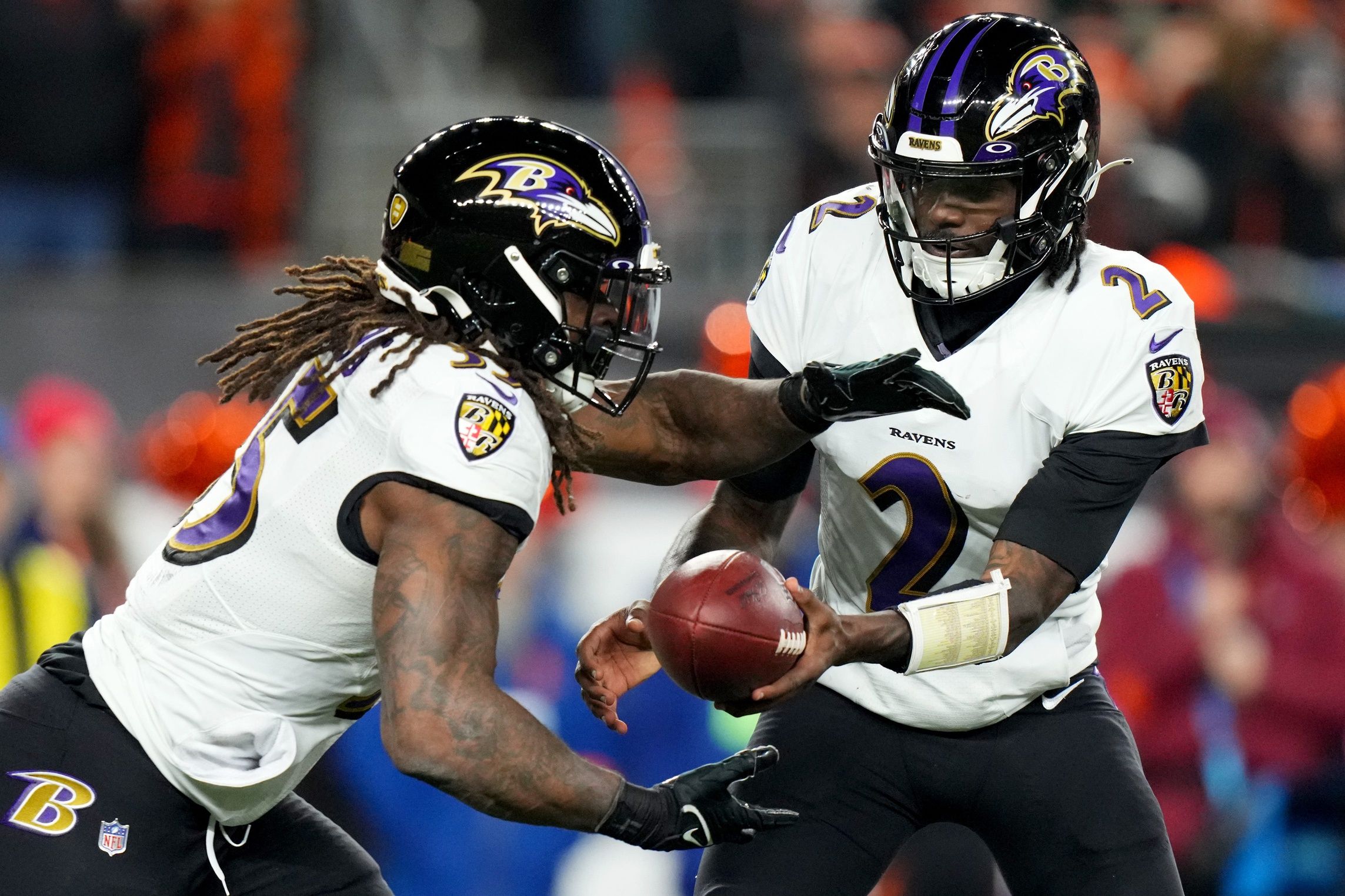 Tyler Huntley (2) hands the ball off to Baltimore Ravens running back Gus Edwards (35) in the fourth quarter during an NFL wild-card playoff football game between the Baltimore Ravens and the Cincinnati Bengals.