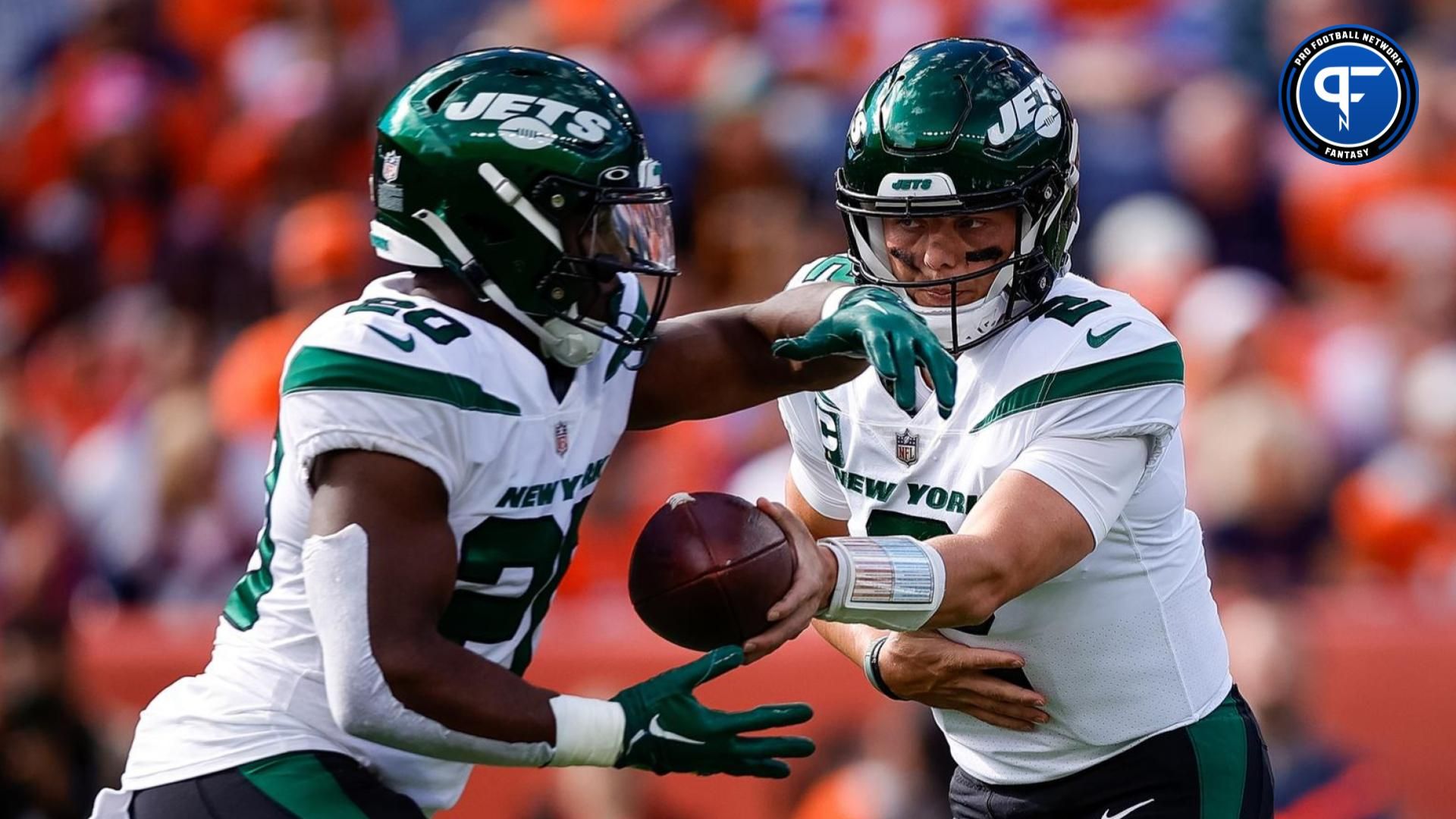 New York Jets quarterback Zach Wilson (2) hands the ball off to running back Breece Hall (20) in the first quarter against the Denver Broncos at Empower Field at Mile High.