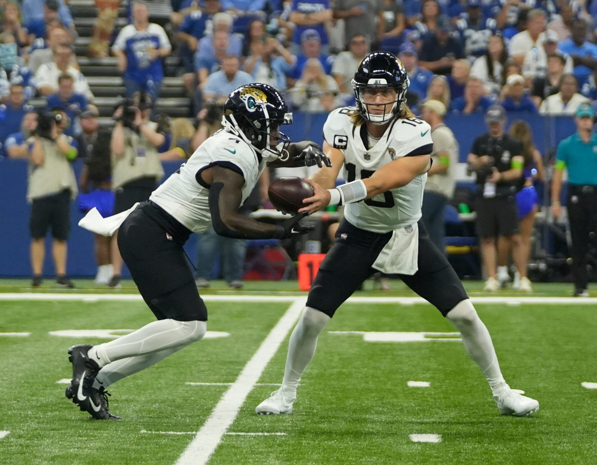 Jacksonville Jaguars quarterback Trevor Lawrence (16) hands the ball off to Jacksonville Jaguars running back Tank Bigsby (4), during a game against the Jacksonville Jaguars at Lucas Oil Stadium in Indianapolis.