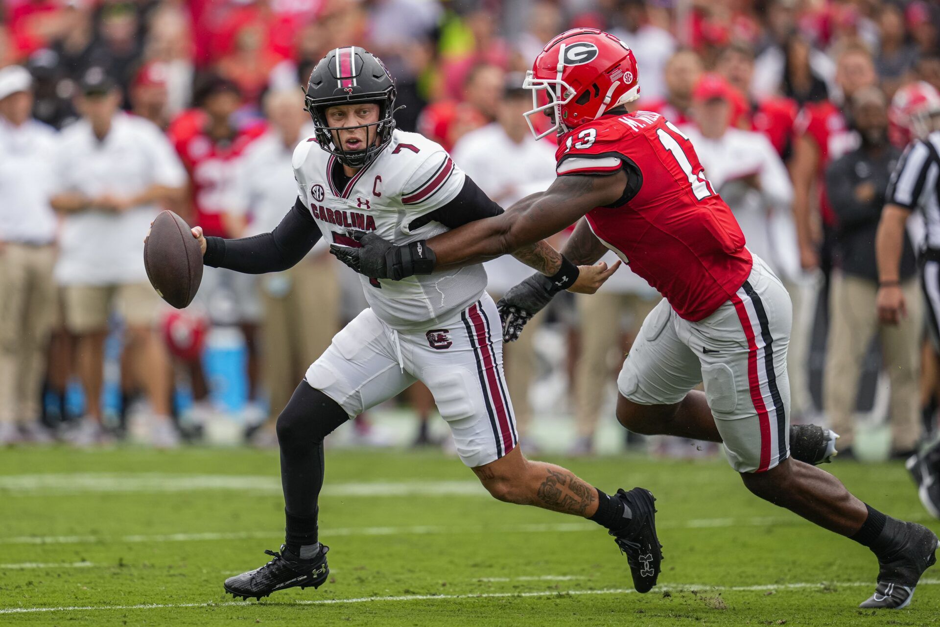 Spencer Rattler (7) is chased by Georgia Bulldogs defensive lineman Mykel Williams (13) during the first half at Sanford Stadium.