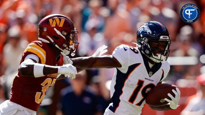 Denver Broncos wide receiver Marvin Mims Jr. stiff arms Washington defender.