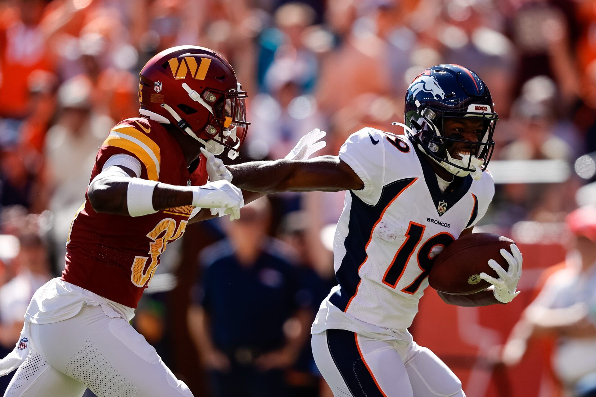 Marvin Mims Jr. (19) runs for a touchdown against Washington Commanders safety Percy Butler (35) after a catch in the first quarter at Empower Field at Mile High.