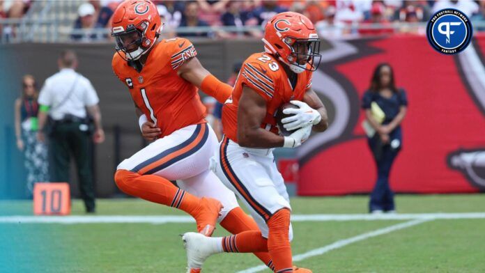 Justin Fields (1) hands the ball off to running back Roschon Johnson (23) against the Tampa Bay Buccaneers during the second quarter at Raymond James Stadium.