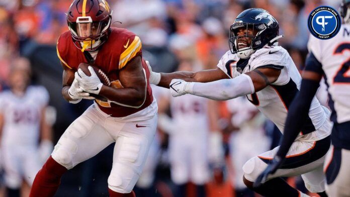 Sep 17, 2023; Denver, Colorado, USA; Washington Commanders running back Antonio Gibson (24) runs through the tackle of Denver Broncos linebacker Jonathon Cooper (0) in the fourth quarter at Empower Field at Mile High.