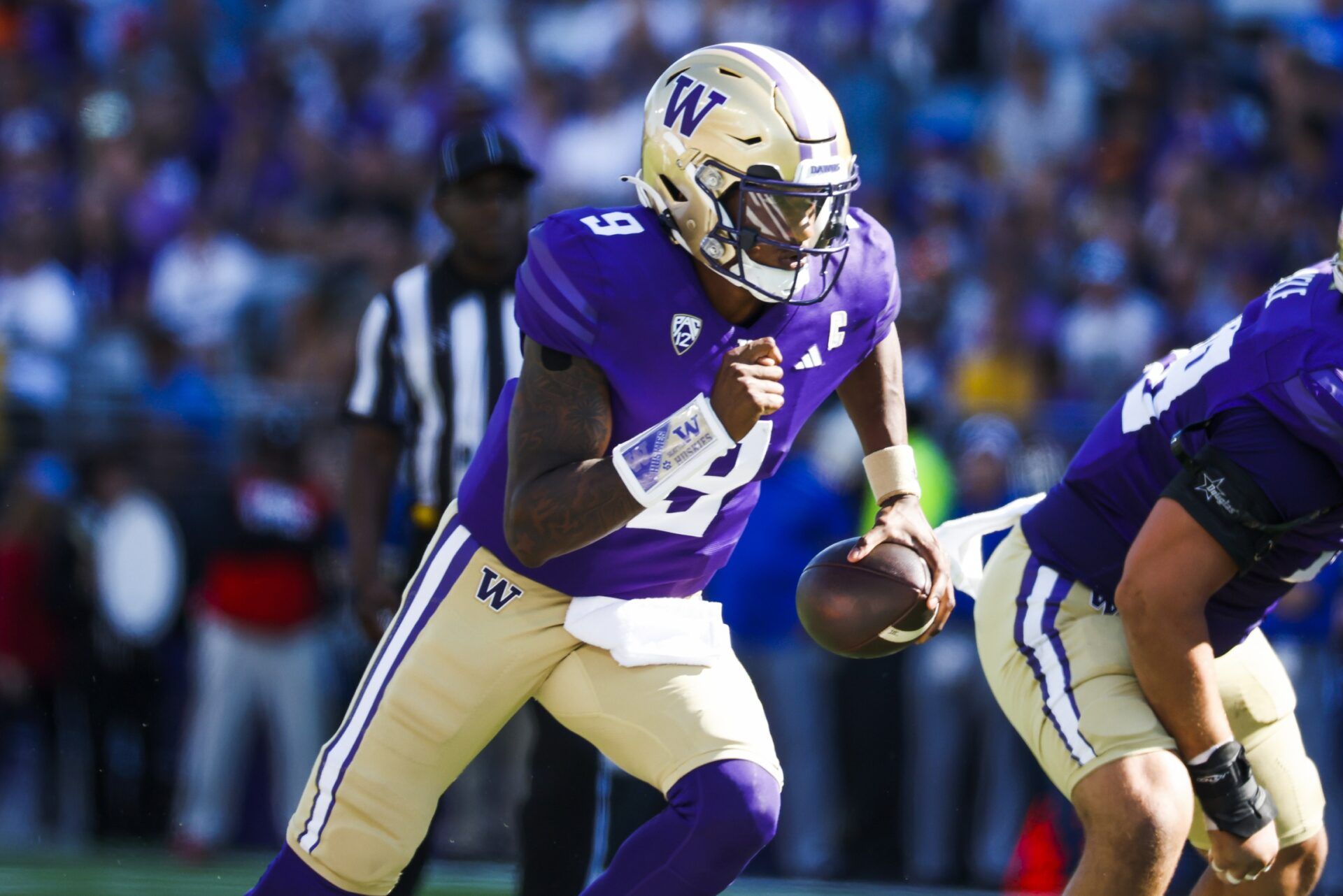 Michael Penix Jr. (9) rushes against the Tulsa Golden Hurricane during the second quarter at Alaska Airlines Field at Husky Stadium.