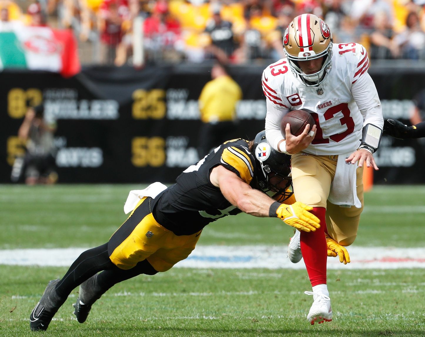 Brock Purdy (13) runs with the ball against Pittsburgh Steelers linebacker Cole Holcomb (55) during the fourth quarter at Acrisure Stadium.