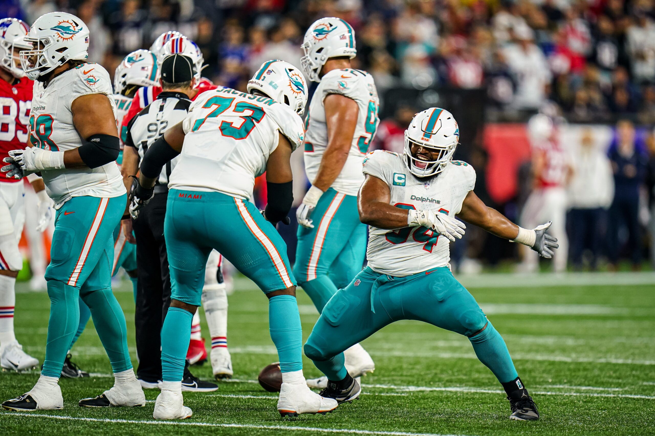 Christian Wilkins (94) celebrate the win against the New England Patriots with guard Austin Jackson (73) in the last seconds of play at Gillette Stadium.