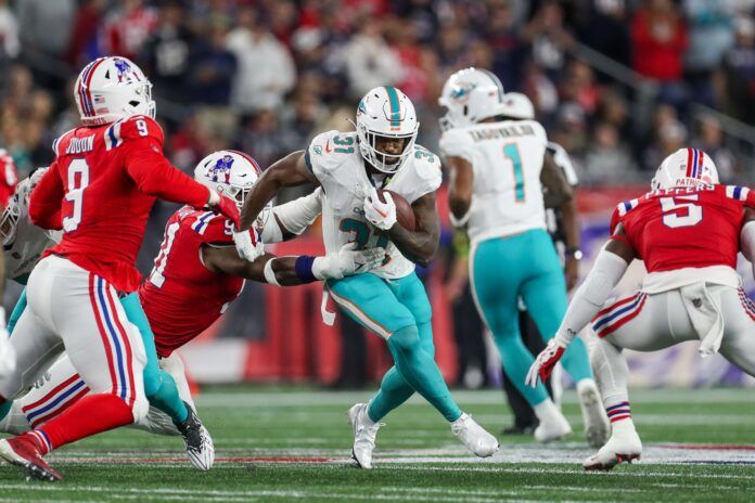 Miami Dolphins running back Raheem Mostert breaks a tackle against the New England Patriots.