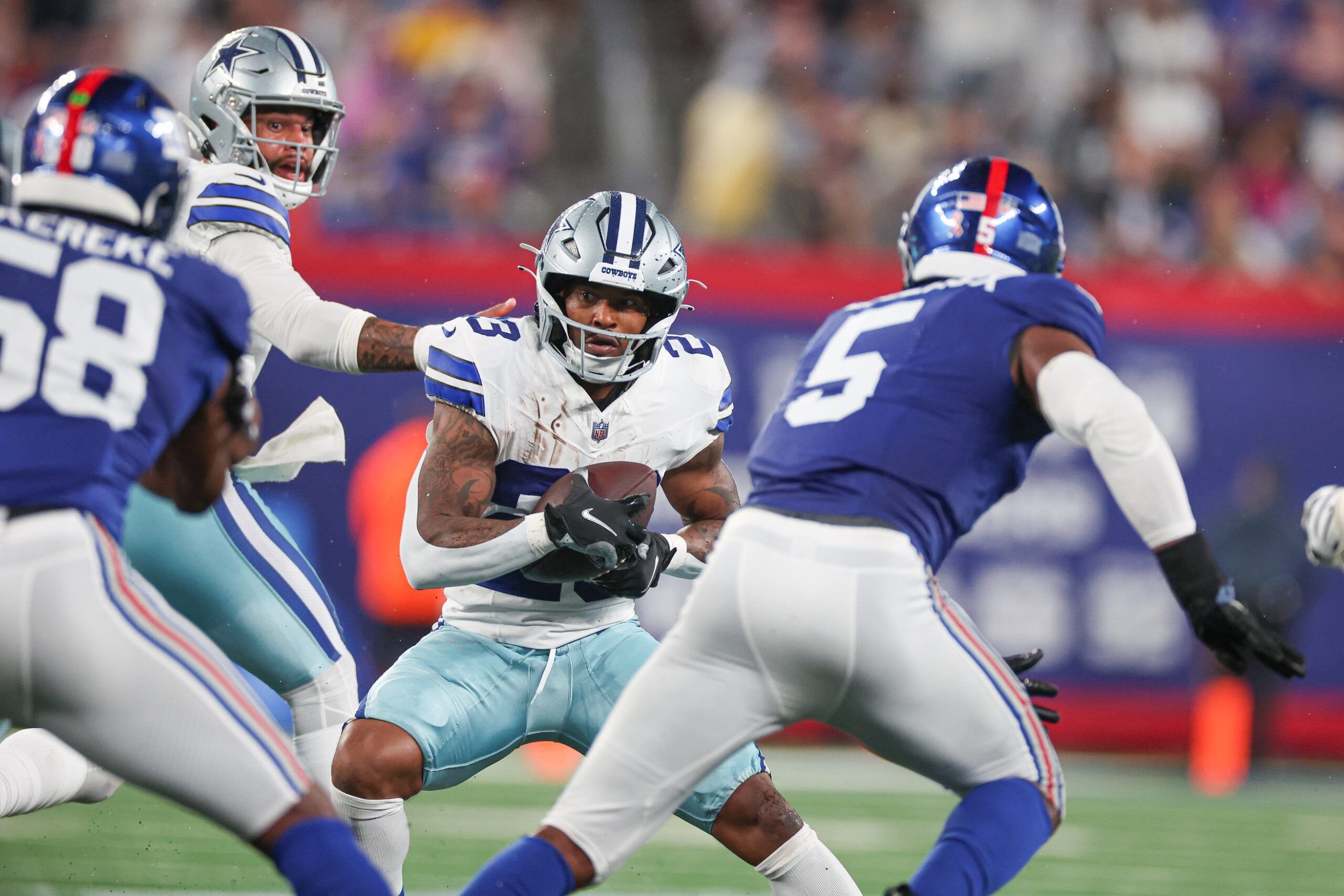 Rico Dowdle (23) carries the ball as New York Giants linebacker Kayvon Thibodeaux (5) defends during the first half at MetLife Stadium.