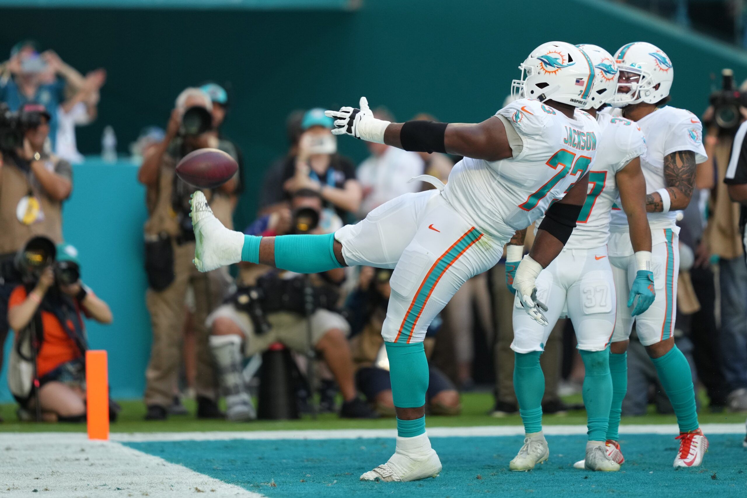 Austin Jackson (73) kicks the ball into the stands after celebrating the touchdown of running back Myles Gaskin (37) during the first half A| at Hard Rock Stadium.