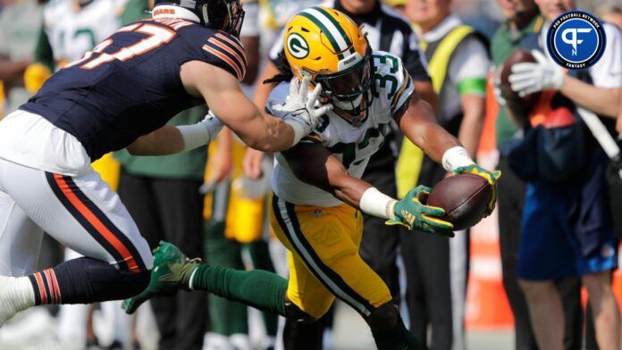 Green Bay Packers running back Aaron Jones (33) lunges for a first down against Chicago Bears linebacker Jack Sanborn (57) in the first quarter during their football game Sunday, September 10, 2023, at Soldier Field in Chicago, Ill.