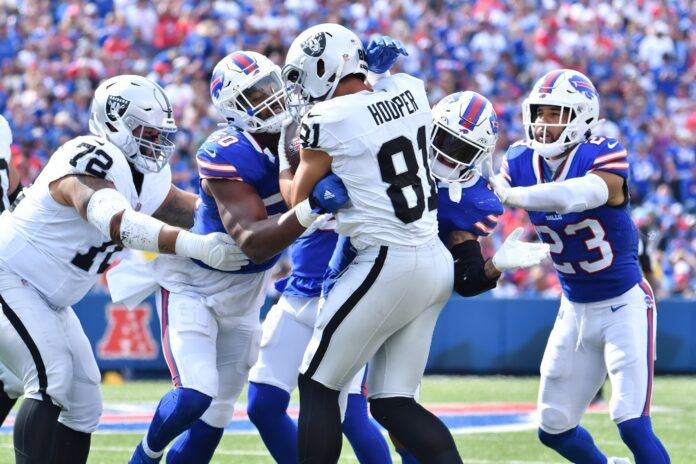 Buffalo Bills defensive end Greg Rousseau (50) and teammates tackle Las Vegas Raiders tight end Austin Hooper (81) in the third quarter at Highmark Stadium.