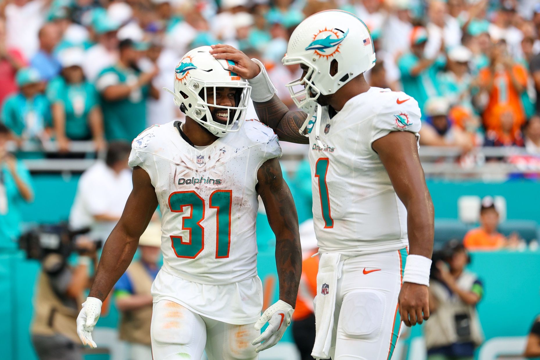 Tua Tagovailoa (1) congratulates running back Raheem Mostert (31) after scoring a touchdown against the Denver Broncos in the third quarter at Hard Rock Stadium.