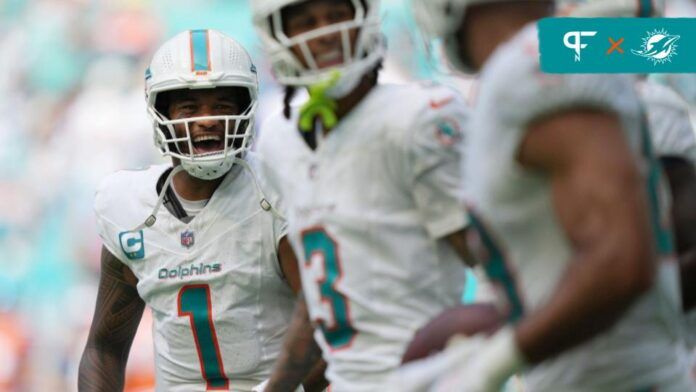 Tua Tagovailoa (1) celebrates a touchdown by Miami Dolphins running back De'Von Achane (28) during the fourth quarter of an NFL game at Hard Rock Stadium in Miami Gardens.