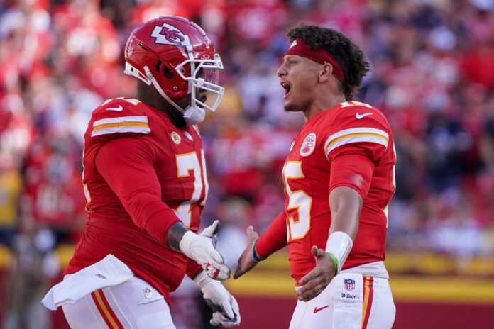 Patrick Mahomes (15) congratulates Kansas City Chiefs offensive tackle Jason Godrick (72) after a score during the first half at GEHA Field at Arrowhead Stadium.