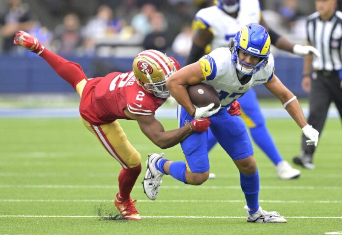 Los Angeles Rams WR Puka Nacua runs through the tackle of San Francisco 49er defender.