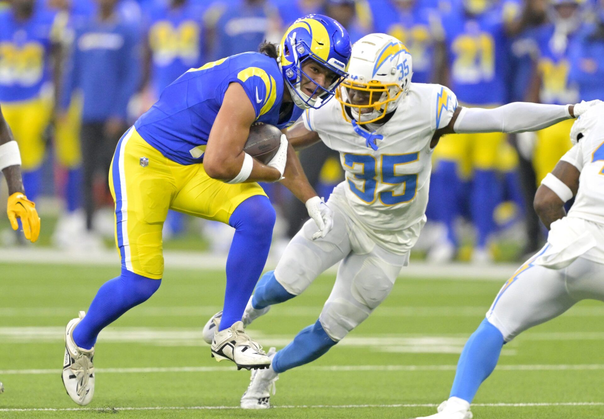 Puka Nacua (17) hangs on the the ball before he is stopped by Los Angeles Chargers cornerback AJ Uzodinma (35) in the first half at SoFi Stadium.