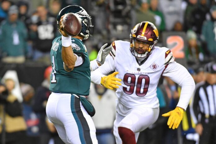 Washington Commanders DE Montez Sweat (90) rushes Philadelphia Eagles QB Jalen Hurts (1) as he throws the ball.