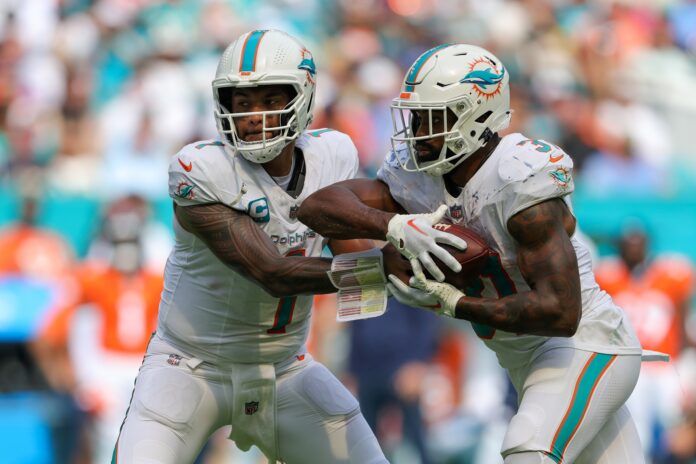 Miami Dolphins quarterback and running back Tua Tagovailoa and Raheem Mostert meet at the mesh point.