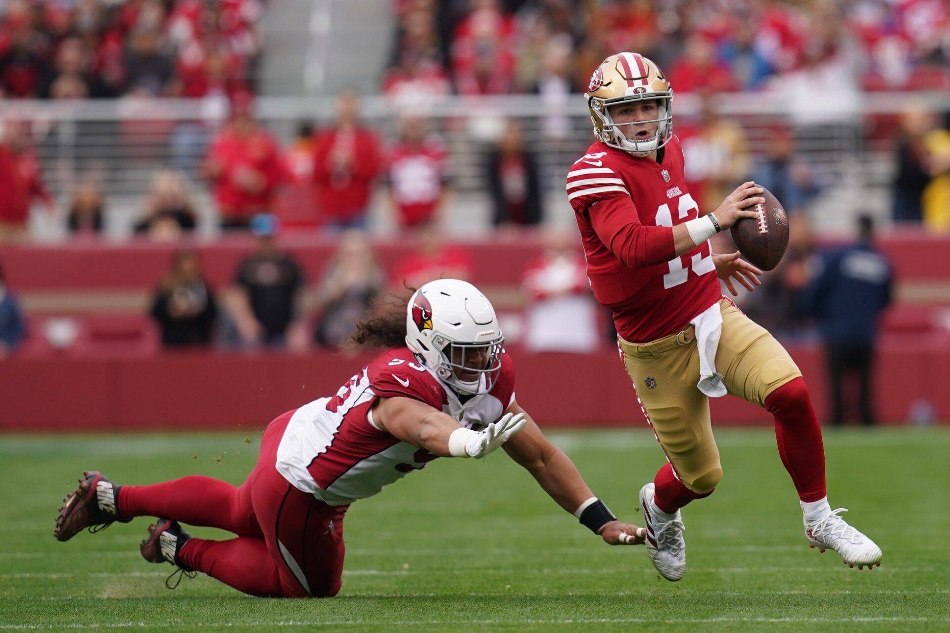 San Francisco 49ers QB Brock Purdy (13) runs away from Arizona Cardinals DT Leki Fotu (95).