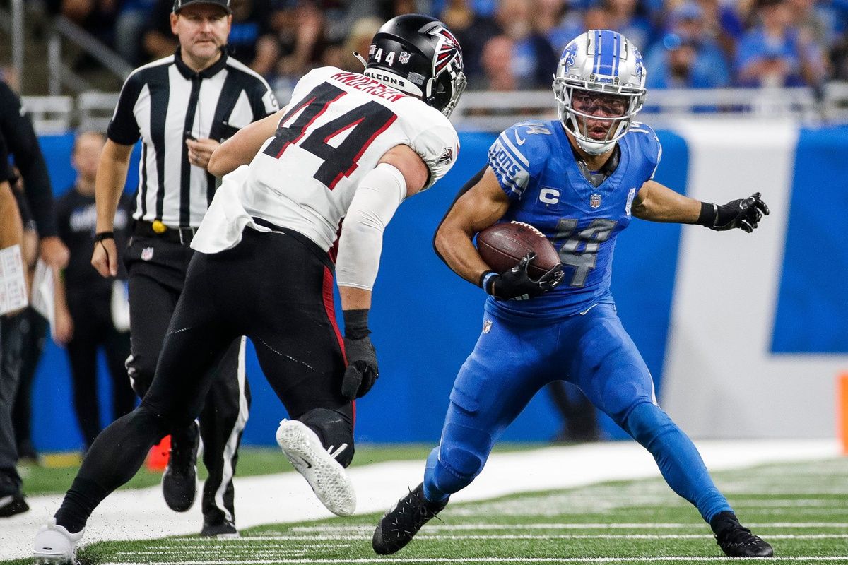 Amon-Ra St. Brown (14) runs against Atlanta Falcons linebacker Troy Andersen (44) during the second half at Ford Field.