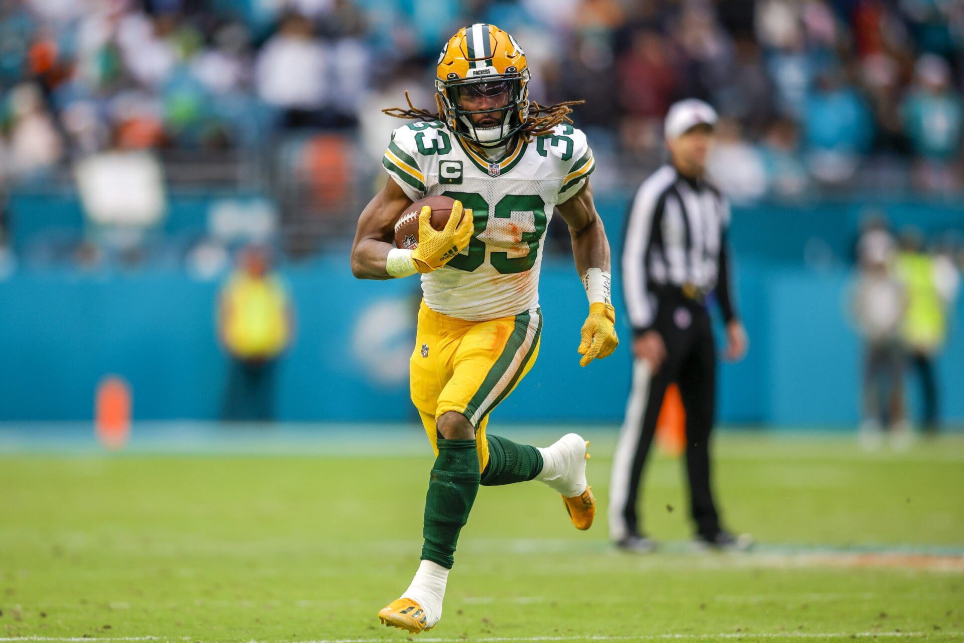 Aaron Jones (33) runs with the football during the fourth quarter against the Miami Dolphins at Hard Rock Stadium.