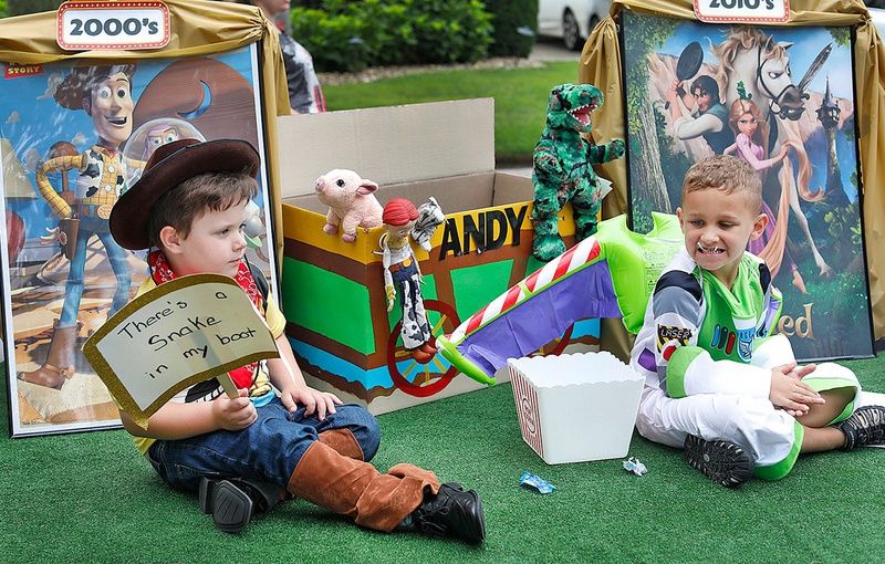 Kids on a Disney-themed float dressed like Woody and Buzz Lightyear from 