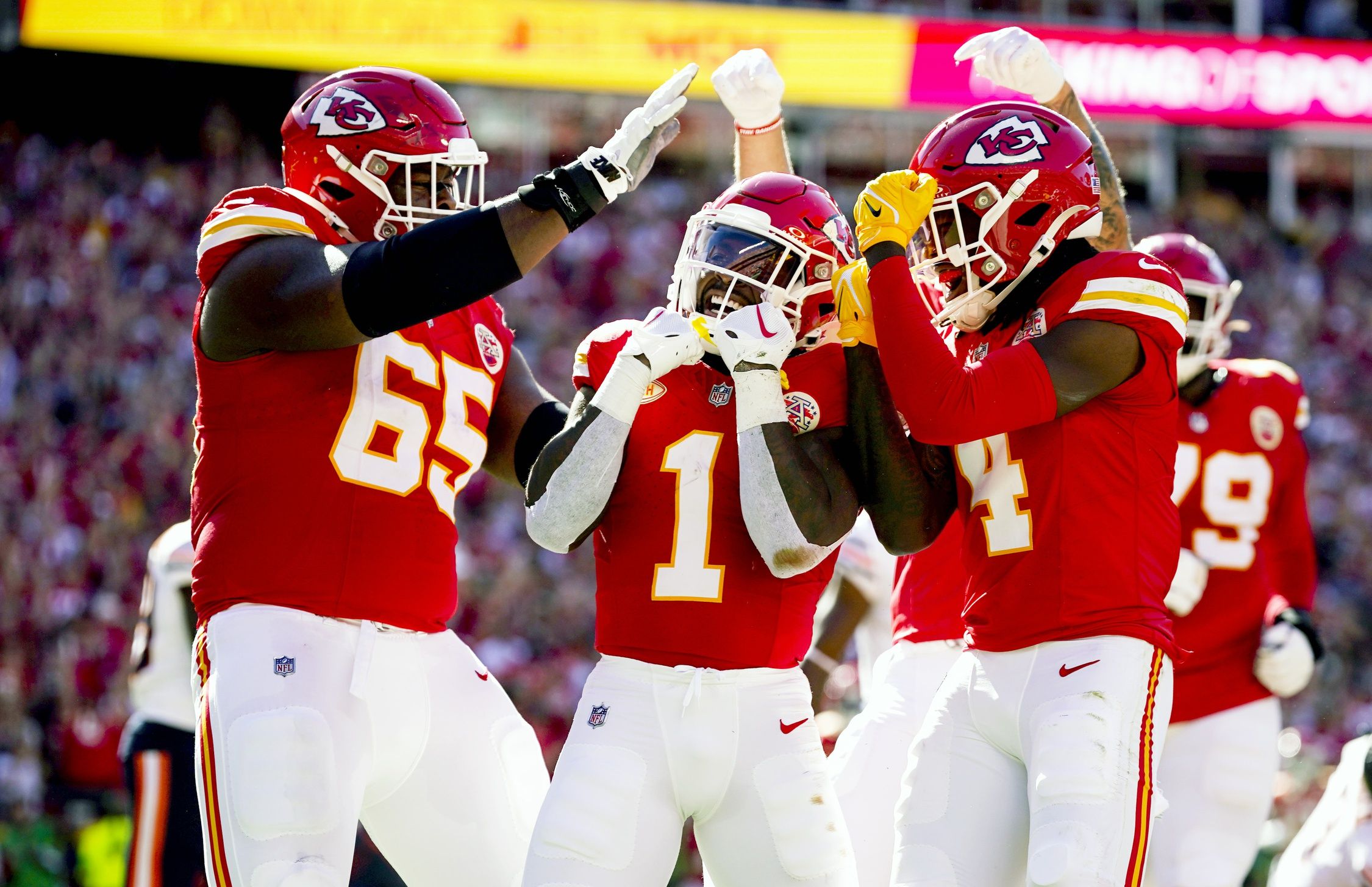 Jerick McKinnon (1) celebrates with guard Trey Smith (65) and wide receiver Rashee Rice (4) after scoring a touchdown against the Chicago Bears during the first half at GEHA Field at Arrowhead Stadium.