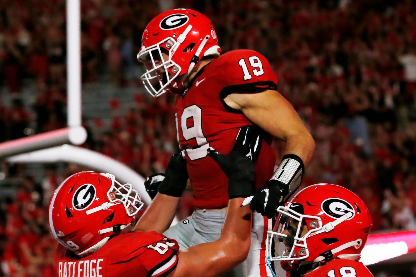 Brock Bowers (19) celebrates with his teammates after scoring a touchdown during the first half.