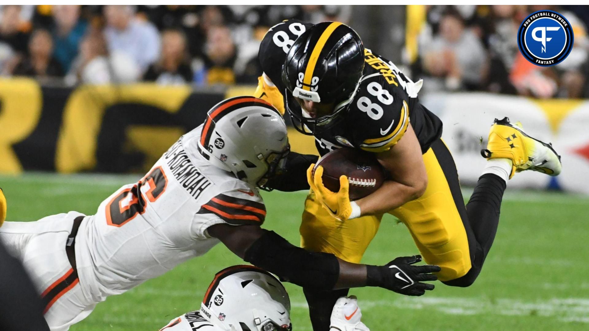 Pittsburgh Steelers tight end Pat Freiermuth (88) is stopped by Cleveland Browns linebacker Jeremiah Owusu-Koramoah (6) and safety Juan Thornhill (1) during the second quarter at Acrisure Stadium.