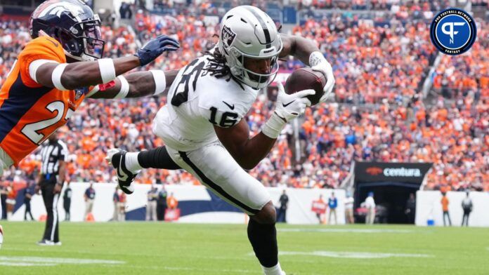 Las Vegas Raiders wide receiver Jakobi Meyers (16) catches a touchdown pass with Denver Broncos cornerback Damarri Mathis (27) defending in the first quarter at Empower Field at Mile High.