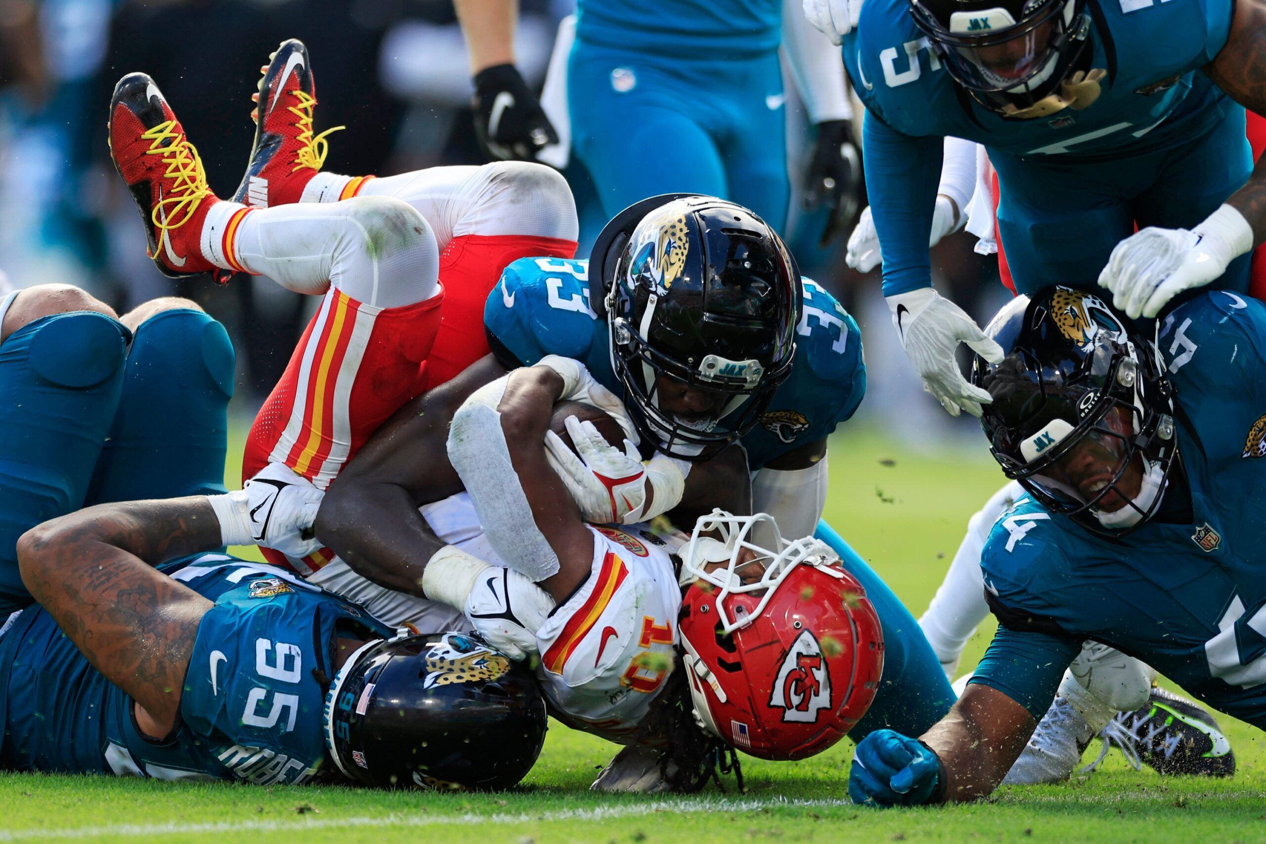 Isiah Pacheco (10), center, is tackled by, from left, Jacksonville Jaguars defensive end Roy Robertson-Harris (95), linebacker Devin Lloyd (33) and linebacker Travon Walker (44) as safety Andre Cisco (5) looks on during the fourth quarter.