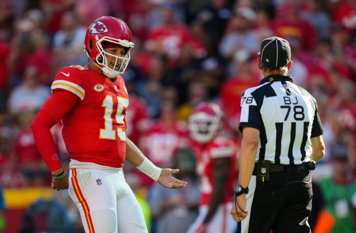 Kansas City Chiefs quarterback Patrick Mahomes (15) talks with back judge Greg Meyer (78) during the first half at GEHA Field at Arrowhead Stadium.