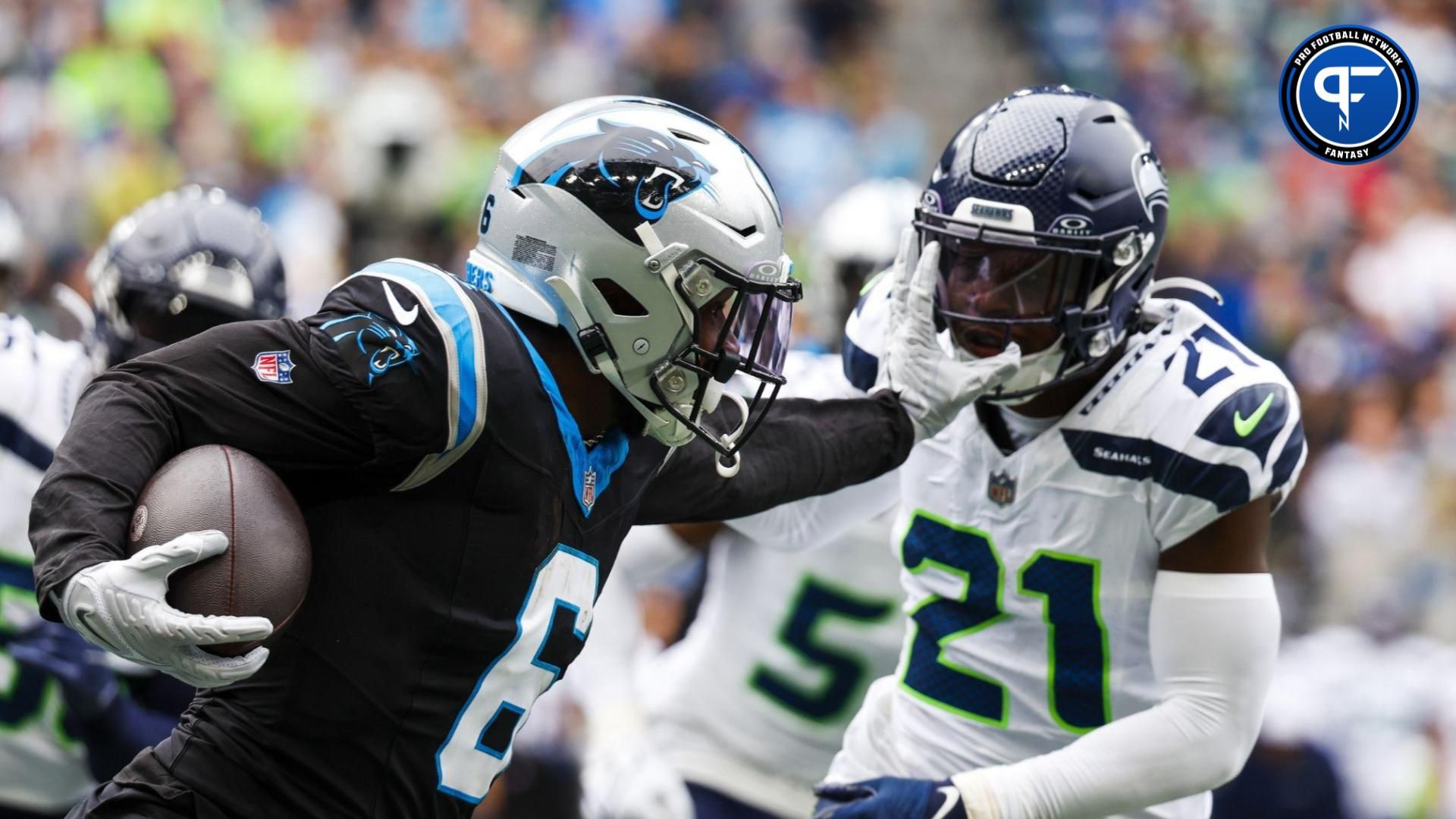 Carolina Panthers running back Miles Sanders (6) stiff-arms away from a tackle attempt by Seattle Seahawks cornerback Devon Witherspoon (21) during the second quarter at Lumen Field.