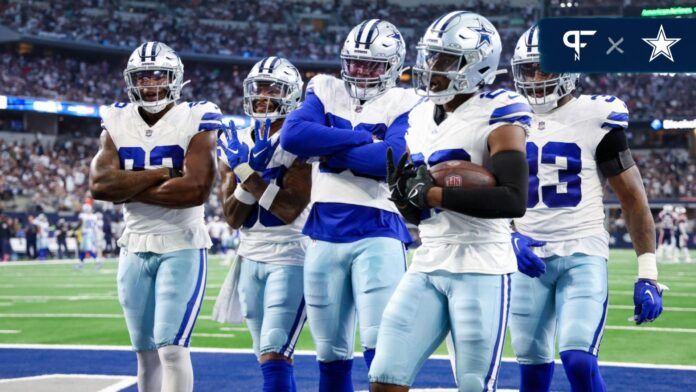 DaRon Bland (26) celebrates with teammates after intercepting a pass during the second half against the New England Patriots at AT&T Stadium.