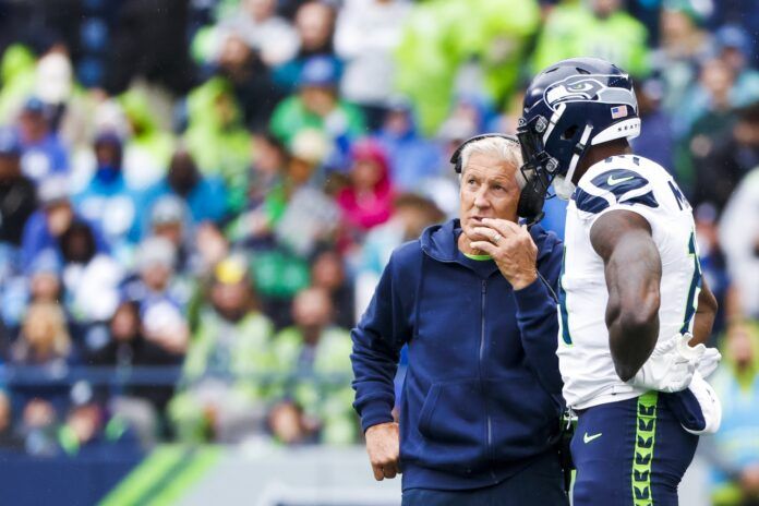 Pete Carroll talks with wide receiver DK Metcalf (14) during a third quarter timeout against the Carolina Panthers at Lumen Field.