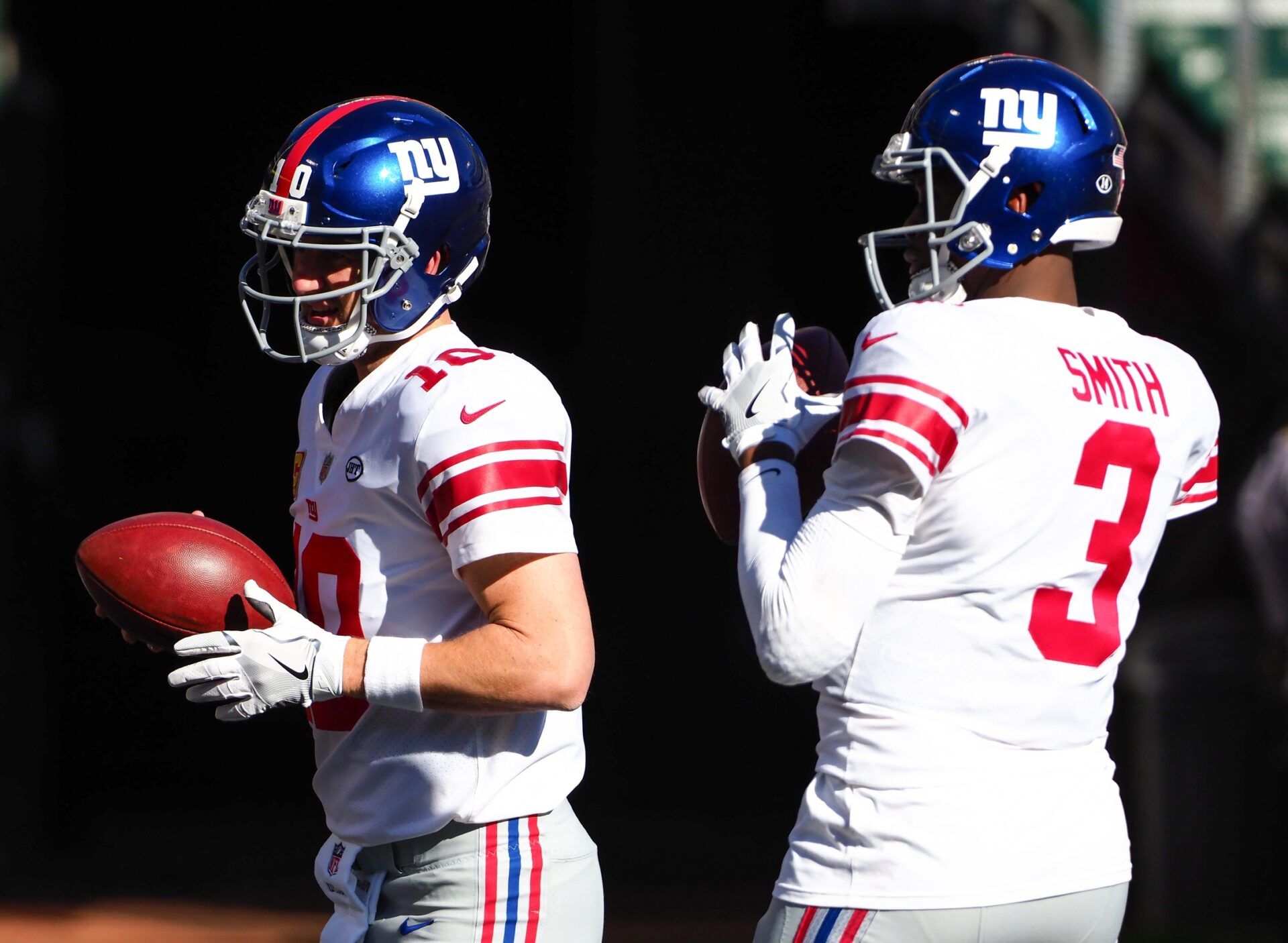 Eli Manning (10) and quarterback Geno Smith (3) warm up before the game against the Oakland Raiders at Oakland Coliseum.