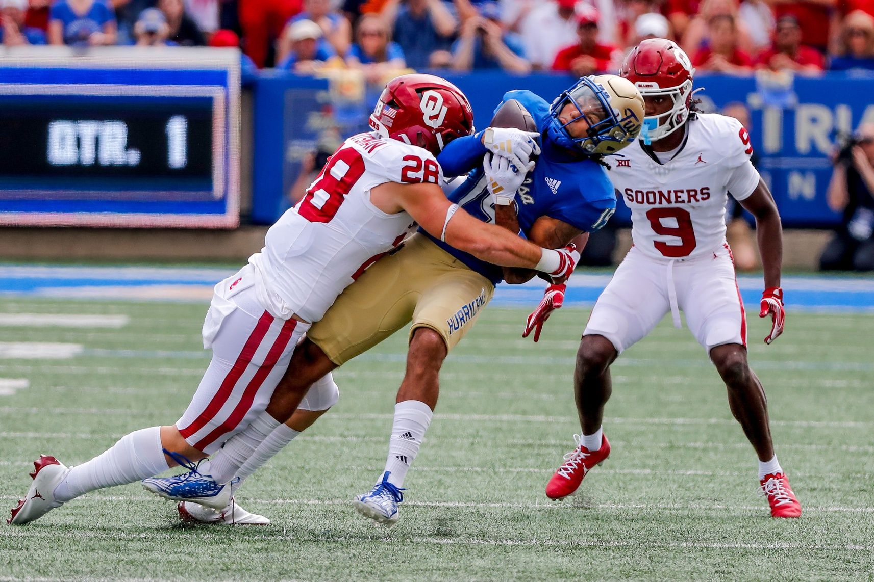 Oklahoma's Danny Stutsman (28) takes down Tulsa's Devan Williams (19).