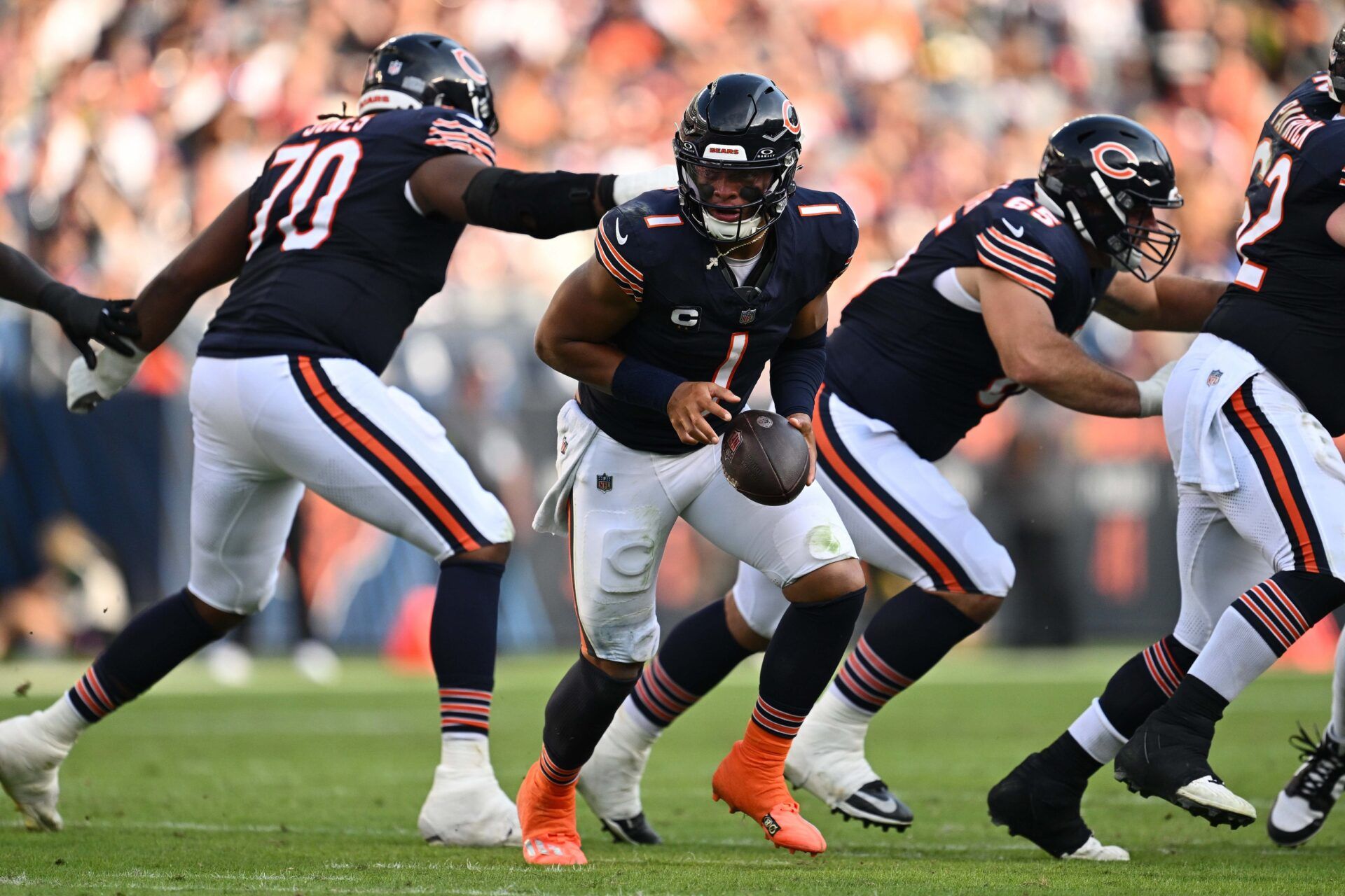 Justin Fields (1) hands off the ball against the Green Bay Packers at Soldier Field.