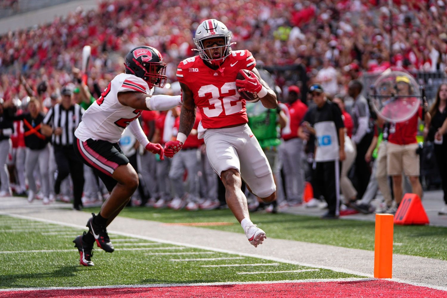 TreVeyon Henderson (32) beats Western Kentucky Hilltoppers linebacker Rashion Hodge (23) into the endzone for a 21-yard touchdown during the first half of the NCAA football game at Ohio Stadium.