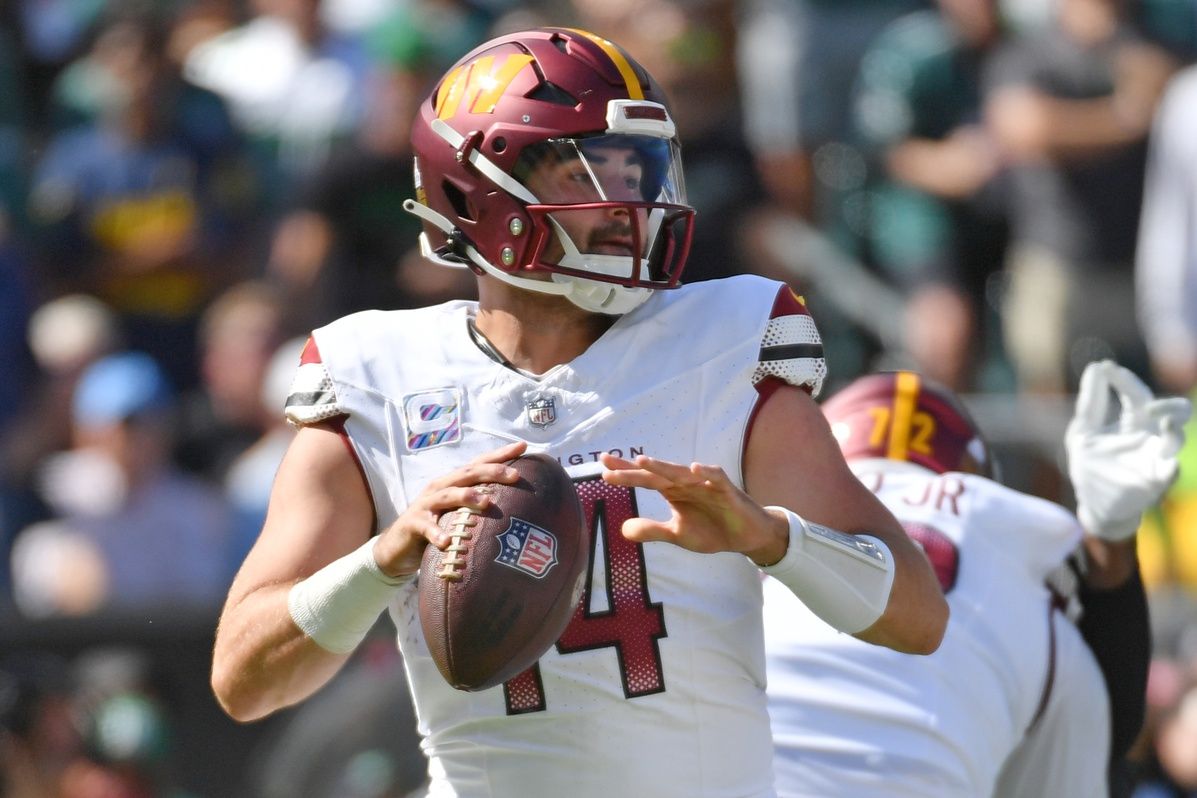 Washington Commanders QB Sam Howell (14) gets set to pass.