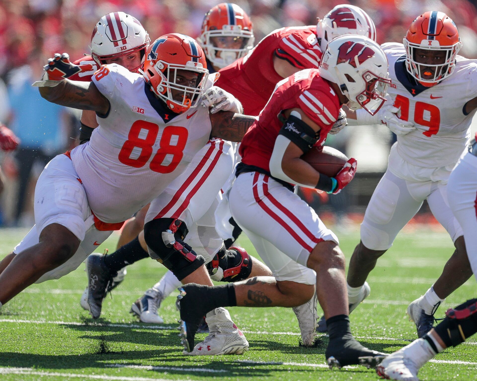 Illinois defensive lineman Keith Randolph Jr. (88) tackles Wisconsin running back Chez Mellusi (1) on Saturday, October 1, 2022, at Camp Randall Stadium