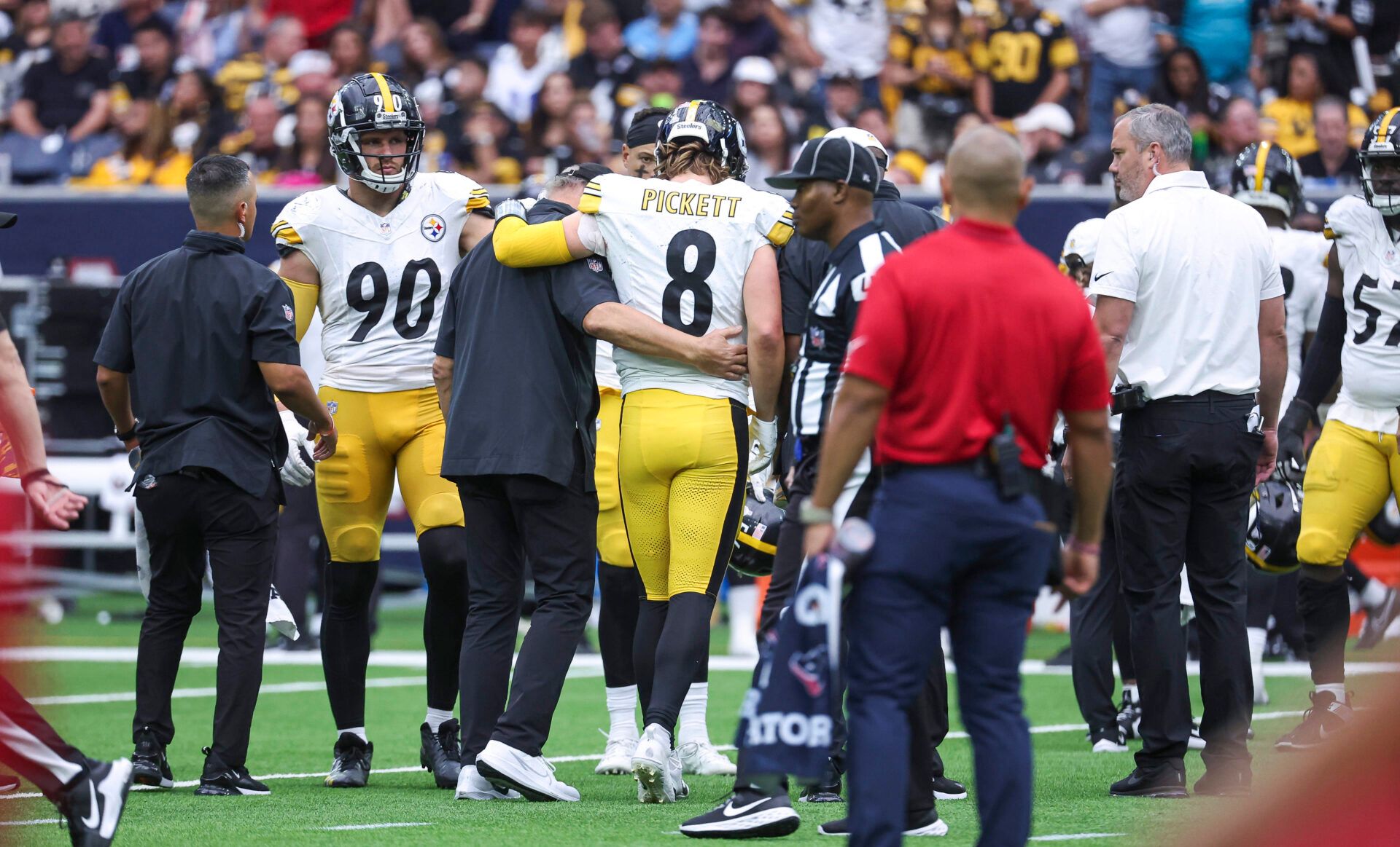 Pittsburgh Steelers quarterback Kenny Pickett (8) is assisted off the field after an apparent injury during the third quarter against the Houston Texans at NRG Stadium.