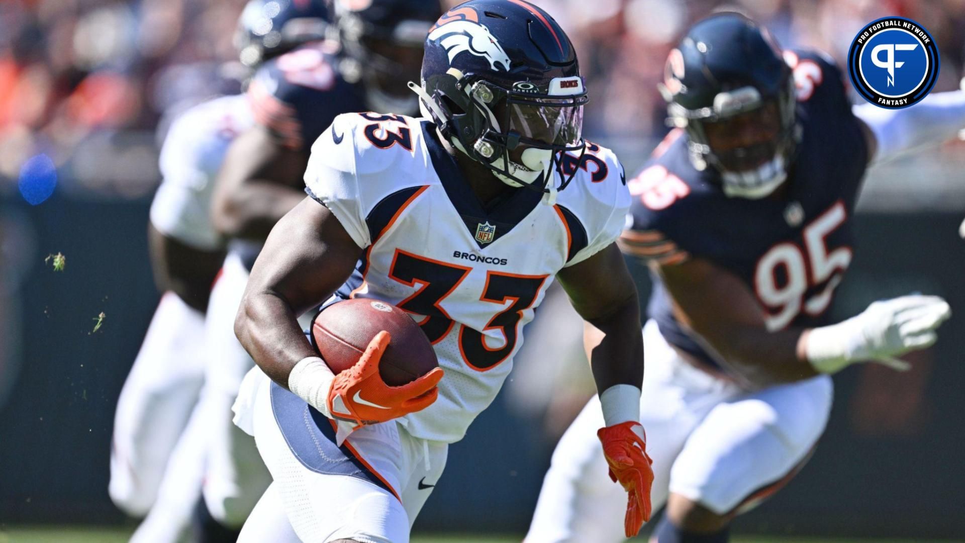 Javonte Williams (33) looks for running room in the first quarter against the Chicago Bears at Soldier Field.