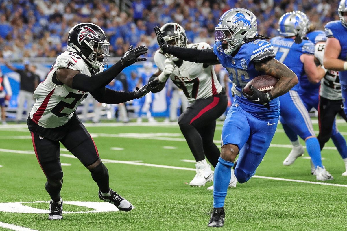 Jahmyr Gibbs (26) runs against Atlanta Falcons safety Richie Grant (27) during the second half at Ford Field.