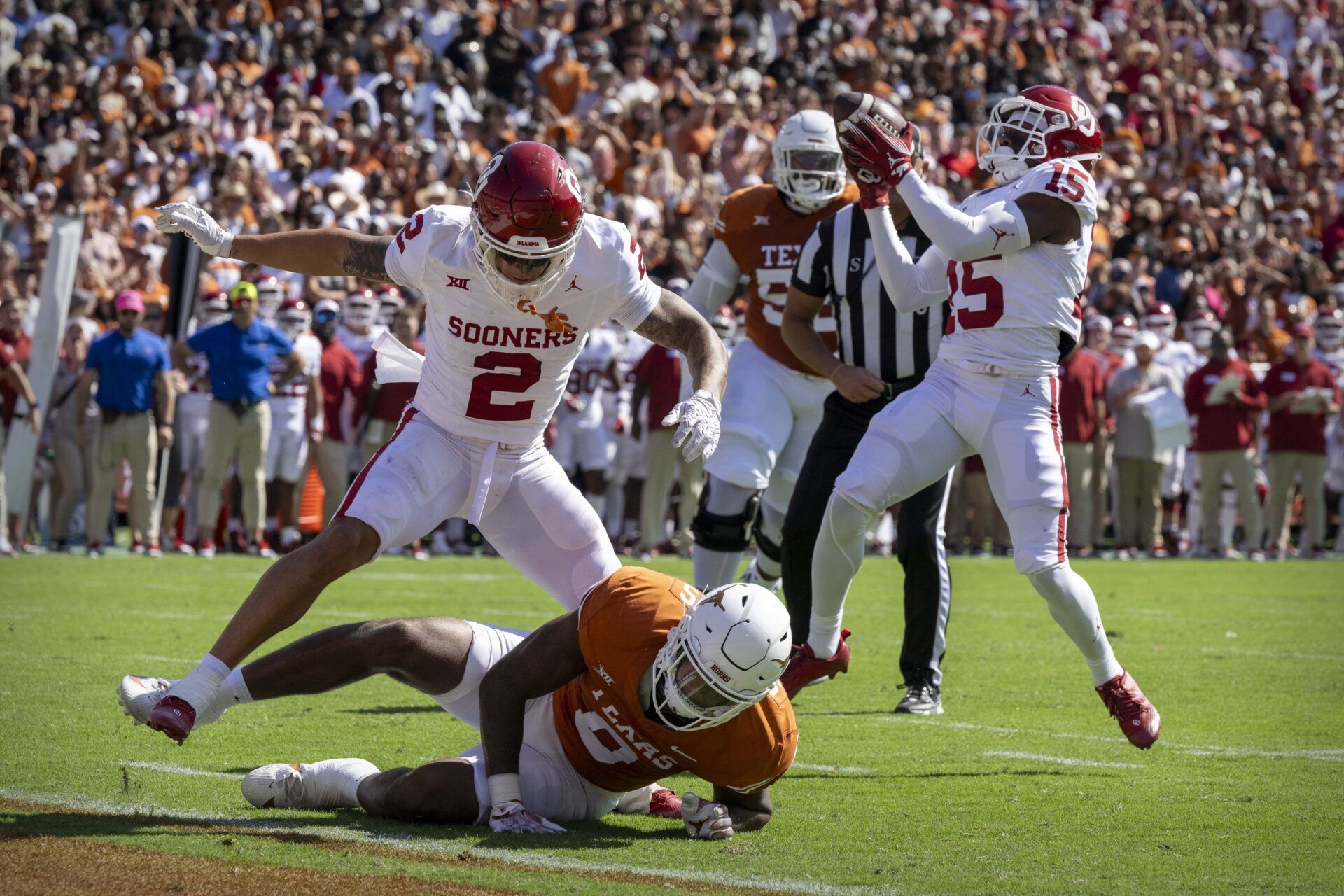 Oklahoma Sooners defensive back Kendel Dolby (15) intercepts a pass off of deflection after defensive back Billy Bowman Jr. (2) hits Texas Longhorns tight end Ja'Tavion Sanders (0) in the end zone.