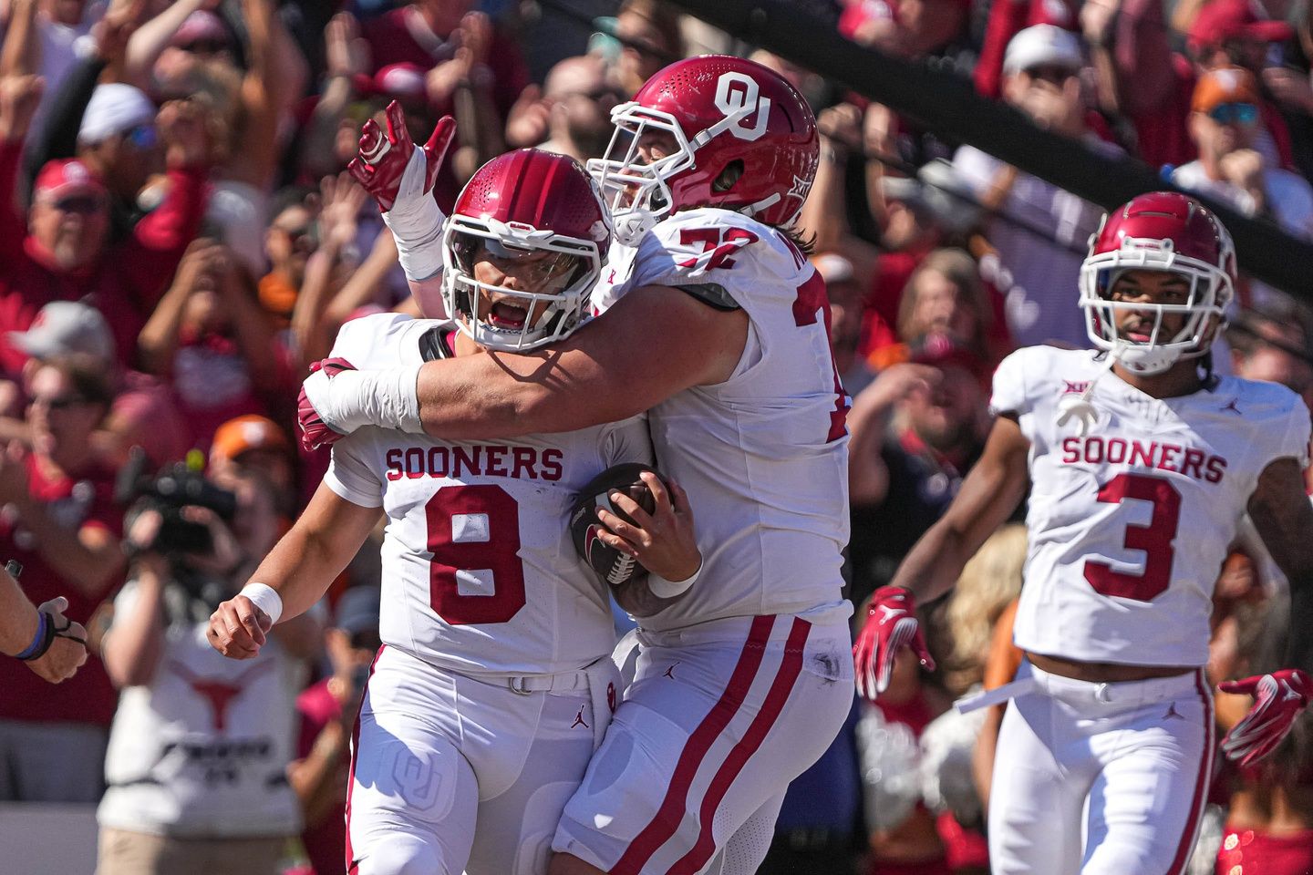 Dillon Gabriel (8) and offensive lineman McKade Mettauer (72) celebrate a rushing touchdown against the Texas Longorns during the game at the Cotton Bowl.