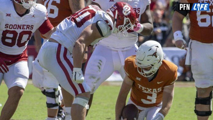 Oklahoma Sooners defensive lineman Ethan Downs (40) stands over Texas Longhorns quarterback Quinn Ewers (3) after Ewers is sacked for a loss during the second half at the Cotton Bowl.